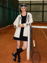 a lady wears a beige zip-up hoodie with black mini dress